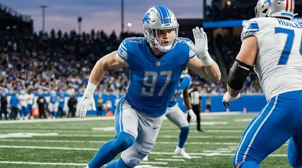 Detroit Lions defensive end Aidan Hutchinson, number 97, in action during an NFL game, rushing the passer.